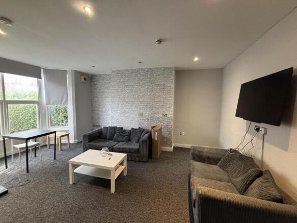 A spacious and well-lit living room featuring c...