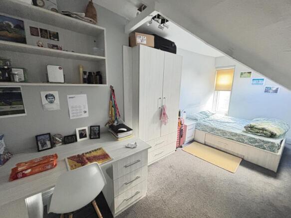 Bright and cozy single bedroom with a neatly ma...