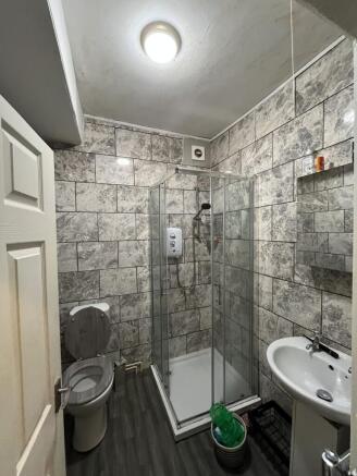 Modern bathroom with grey tiled walls, a shower...