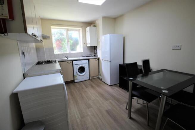 Bright fitted kitchen with a large window and s...