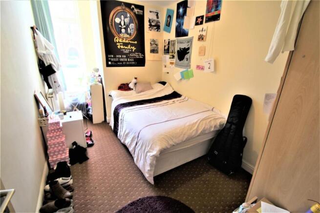 Bright and cozy single bedroom with a neatly ma...