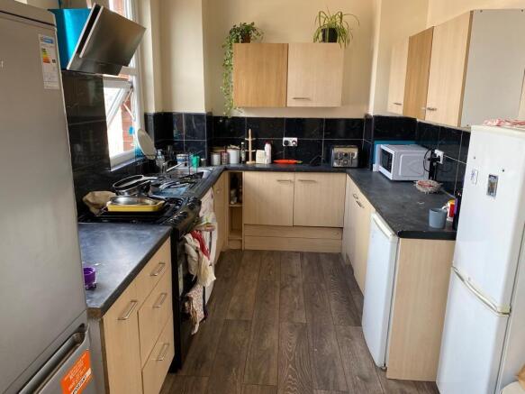 A functional kitchen with wooden cabinets, blac...