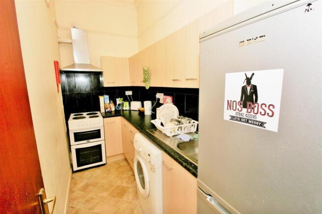 A compact kitchen area with basic appliances in...