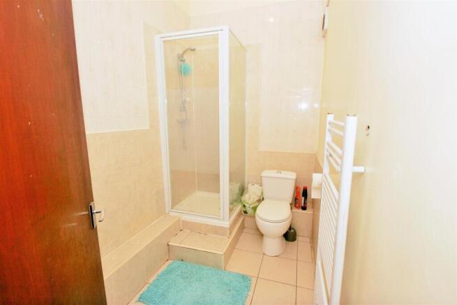 A clean, functional bathroom with a shower encl...