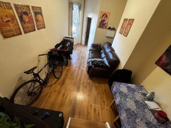 Long, narrow living area with wood-effect floor...