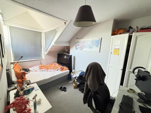 A cozy bedroom featuring a double bed, a study ...