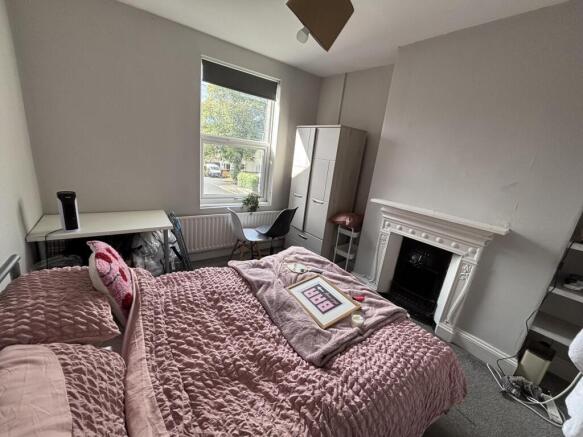 A spacious and well-lit master bedroom featurin...