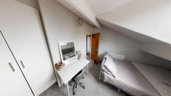 A bright and tidy single bedroom featuring a be...