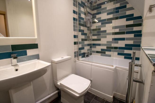 Contemporary bathroom with a tiled bath-shower ...