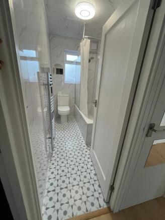 Modern bathroom with patterned tile floor, whit...