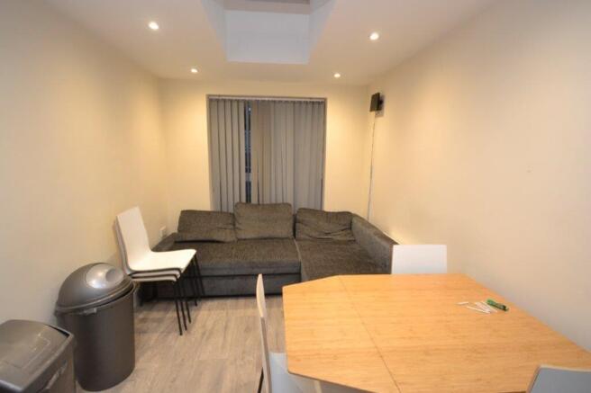 A tidy, well-lit living room with a sofa and di...