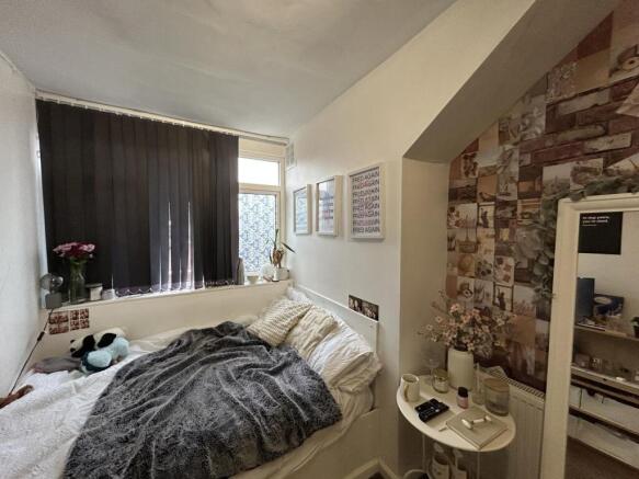 A cozy bedroom featuring a large window dressed...