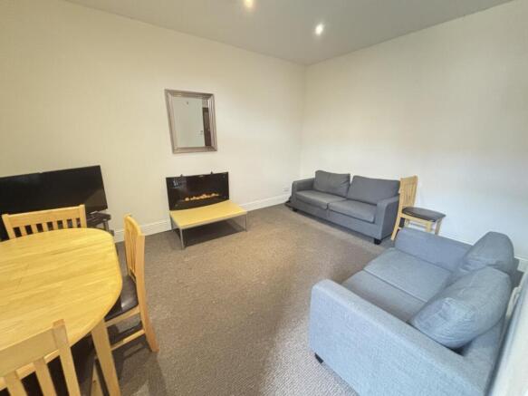 A spacious, well-maintained living room featuri...