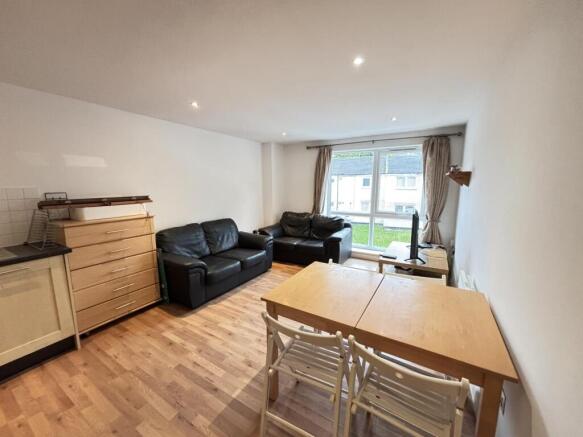 A spacious and well-lit living room with modern...