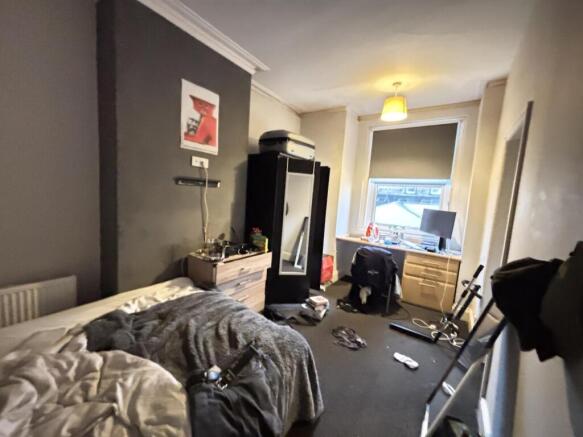 A cozy bedroom featuring a double bed, a desk a...