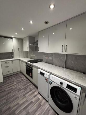 Modern, well-maintained kitchen with sleek whit...