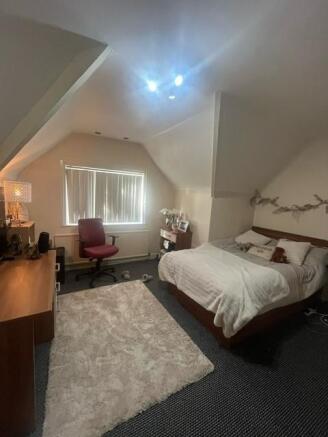 A spacious, inviting bedroom featuring a large ...