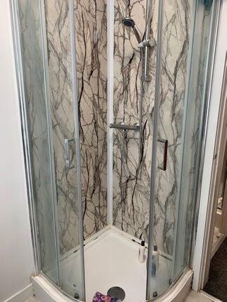A modern enclosed shower unit with clear glass ...