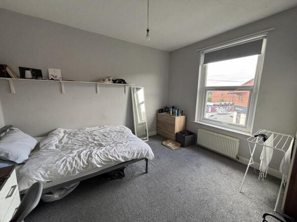 A well-lit double bedroom featuring a comfortab...