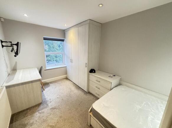 A well-maintained bedroom with a single bed, a ...
