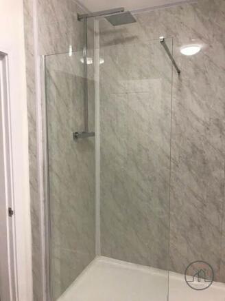 Modern tiled walk-in shower with frameless glas...