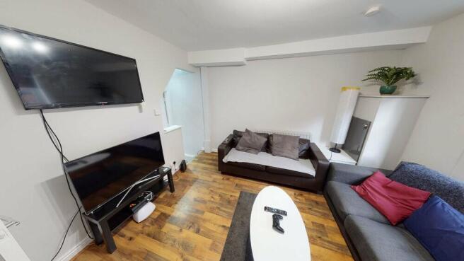 A spacious and well-lit living room featuring a...