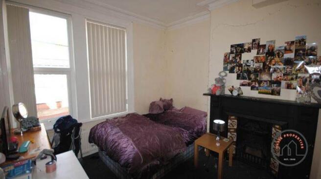 A spacious, well-lit master bedroom featuring a...