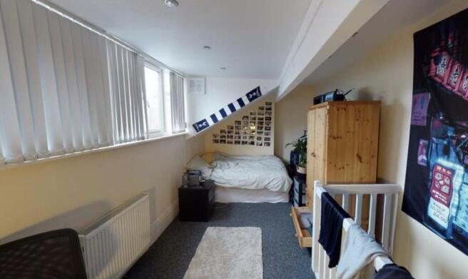 A bright and tidy bedroom featuring a comfortab...