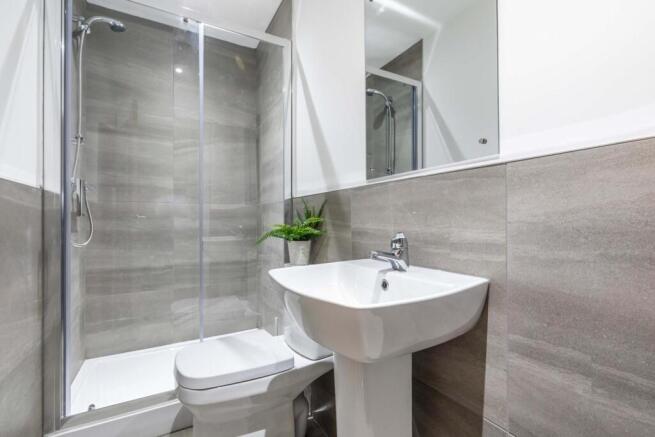 Modern bathroom suite with a glass-enclosed sho...