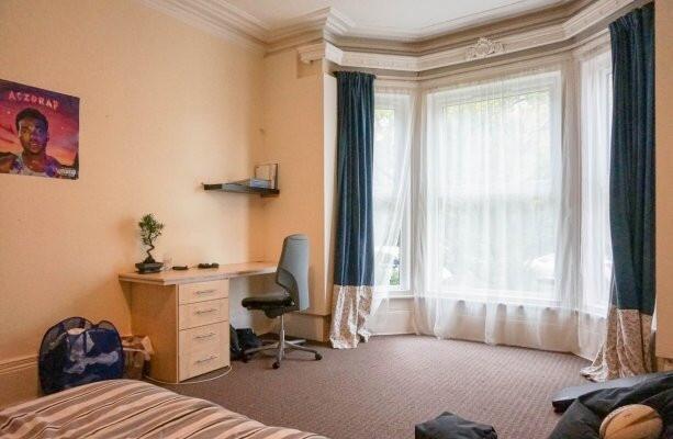 Bright double bedroom with a large bay window a...