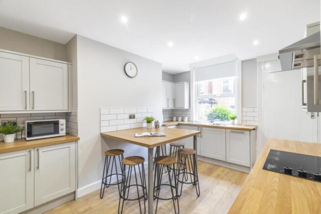 Bright, modern kitchen with light wood worktops...