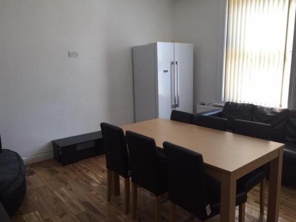 Bright furnished living area with a dining tabl...