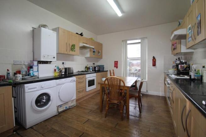 Bright communal kitchen with ample worktops, in...