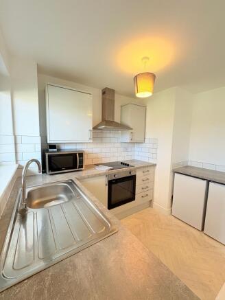 Bright, modern kitchen with integrated oven and...