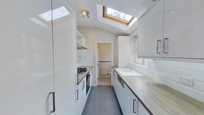 Bright, modern galley kitchen with sleek white ...