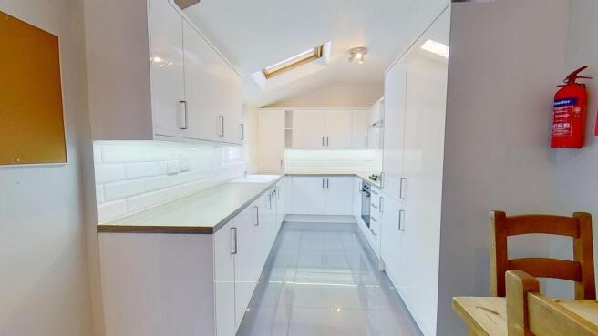 Bright, modern galley kitchen with high-gloss w...