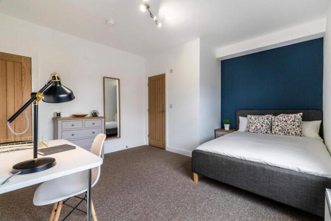 Bright, modern master bedroom with a comfortabl...