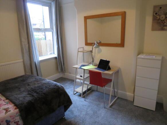 Bright, neatly presented bedroom with a study a...