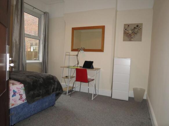 Bright, neatly presented bedroom with a study d...