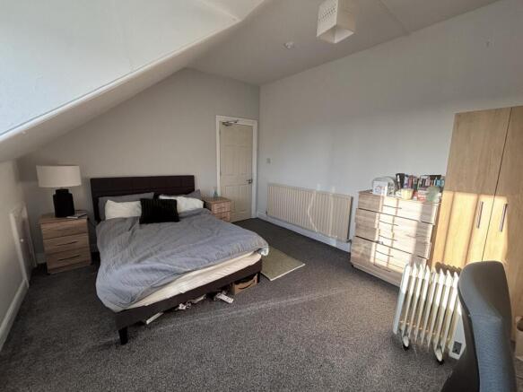 Spacious attic-style bedroom with a double bed,...