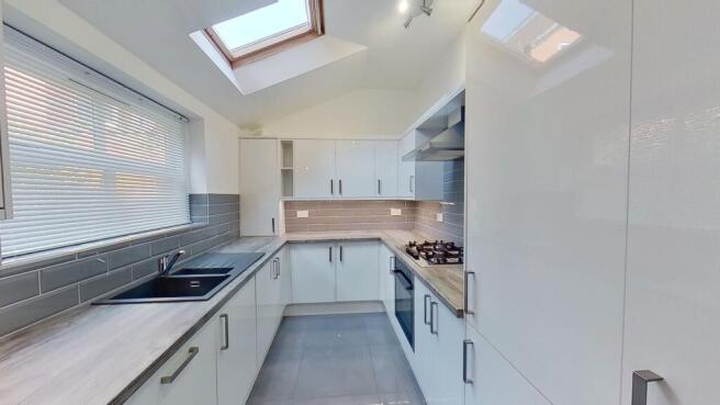 Bright modern galley kitchen with gloss white c...