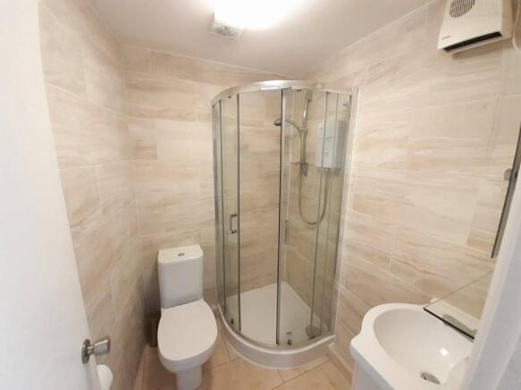 Bright, modern bathroom with a curved glass sho...