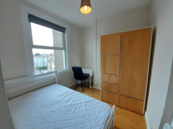 Bright double bedroom with a large window, simp...