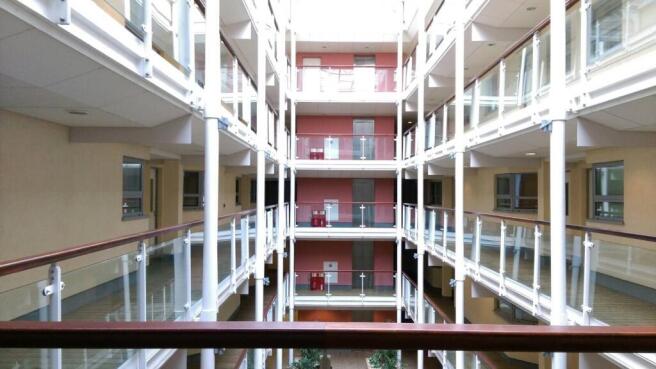 Bright, modern internal atrium with glass balus...