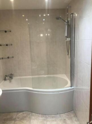 A spacious and modern bathroom featuring a styl...