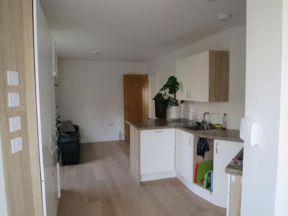 Bright open-plan kitchen with light wood floors...