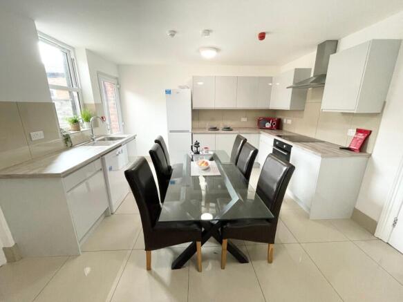 Bright modern kitchen with a central glass dini...
