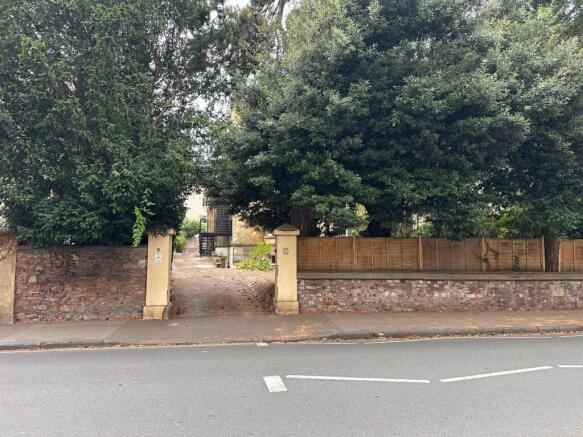 Street-front entrance with stone boundary wall,...
