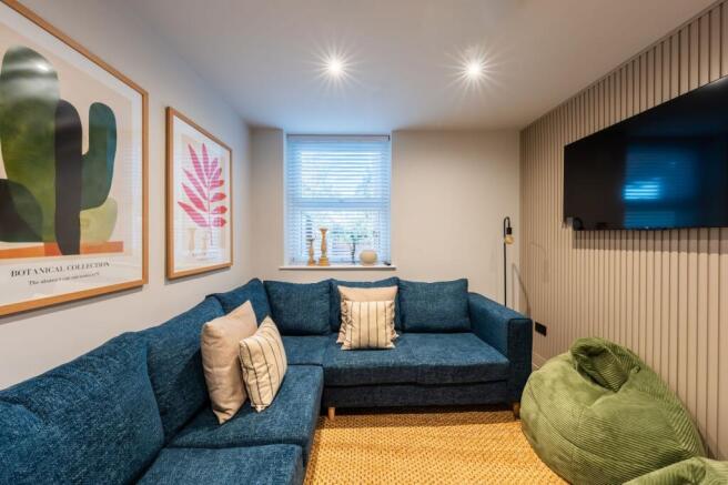 Contemporary snug-style living room with a deep...