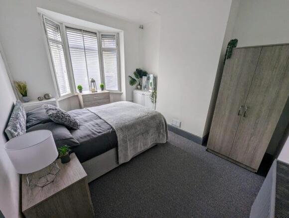 Bright, neatly styled double bedroom with a com...